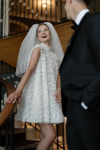 Lachende Braut mit Bräutigam auf Treppe