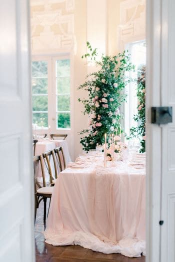 Modern, romantische Tischdekoration mit rosa Dekoelementen und Kerzen