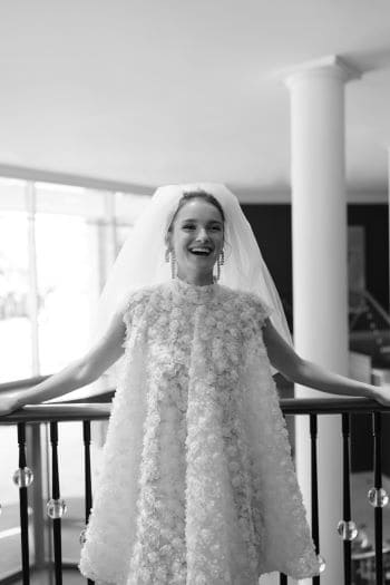 Lächelnde Braut im Standesamt mit modernem kurzen Hochzeitskleid