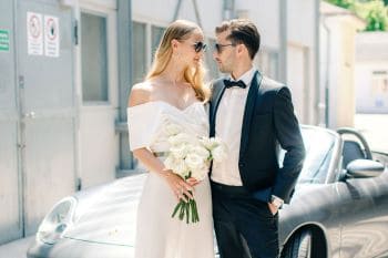 Brautpaar draußen vor Porsche