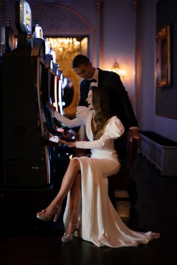 Brautpaar sitzend am Spielautomat im Casino