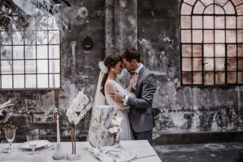 Industrial Wedding Brautpaar hinter gedeckten und dekorierten Tisch