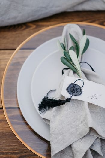 Italienische Tischdekoration mit Olivenblätter und Platzkarten