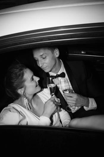 Brautpaar in Limousine beim Sekt trinken
