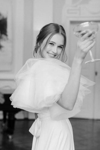 Braut beim Sektempfang mit Sektglas in der Hand