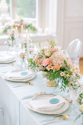 Blumengesteck auf dekorierten Tisch im blauen Stil