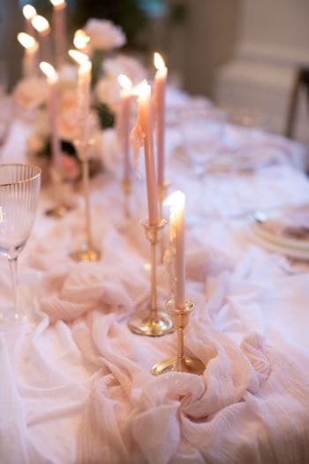 Modern, romantische Tischdekoration mit rosa Dekoelementen und Kerzen
